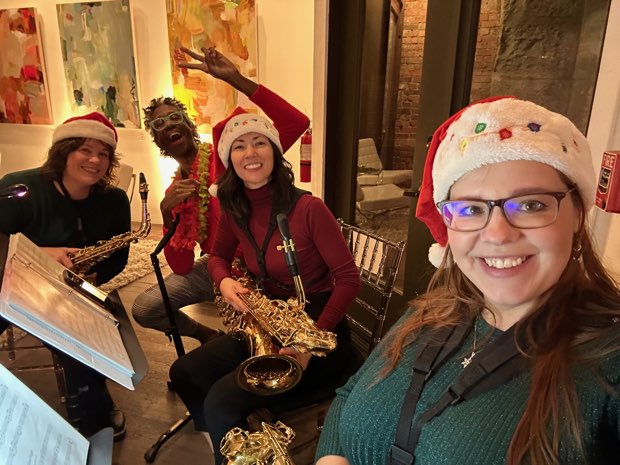 The group in Santa hats playing a holiday gig